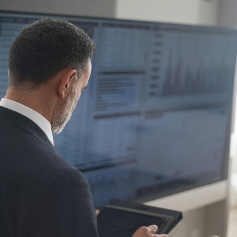 A Man in Black Suit Holding a Digital Tablet