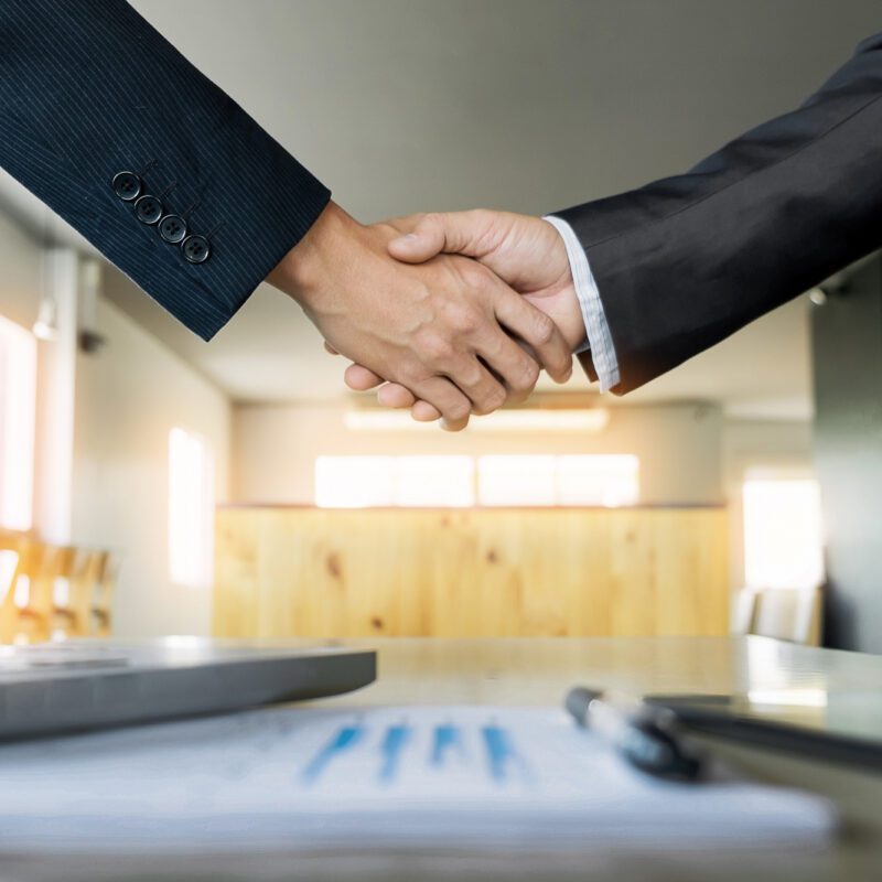 Two confident business man shaking hands during a meeting in the office, success, dealing, greeting and partner concept